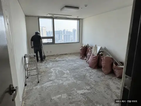 소형 실내 공간의 마감재가 제거되고 폐기물이 정리된 현장