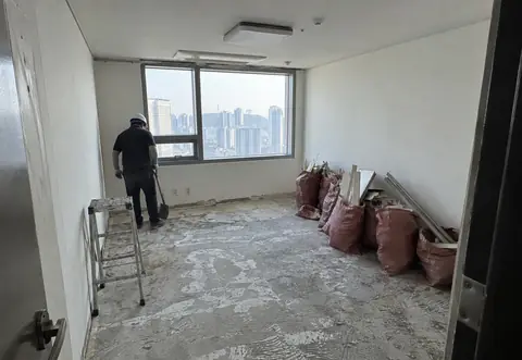 소형 실내 공간의 마감재가 제거되고 폐기물이 정리된 현장