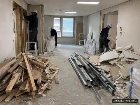 철거된 목재와 금속 자재가 분류되는 실내 현장